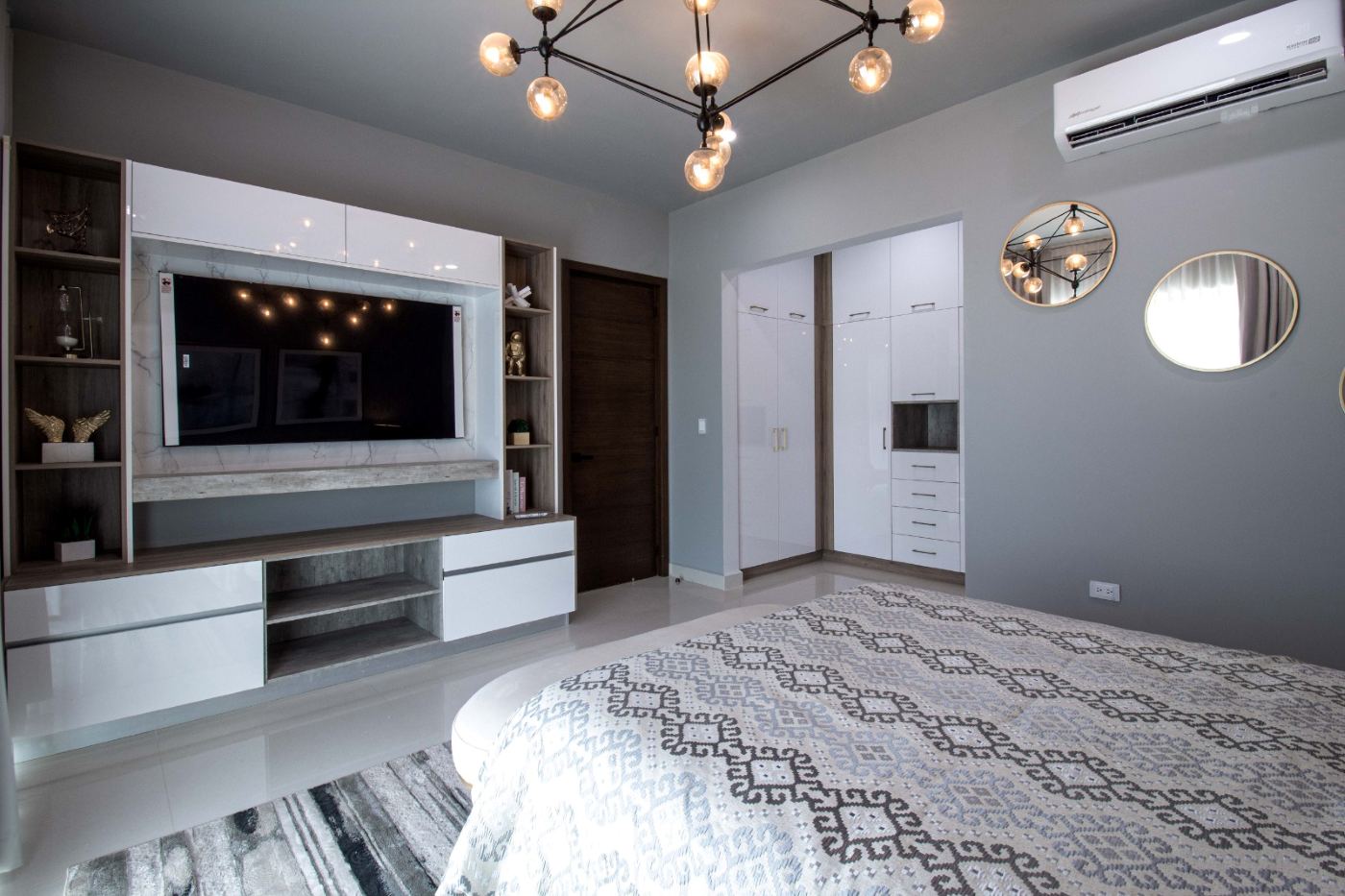 Recámara con mueble de televisión blanco a medida y repisas laterales